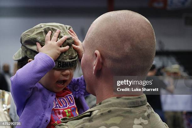 Spc. Brian Bennett of the U.S. Army's 3rd Brigade Combat Team, 1st Infantry Division, holds his 2-year-old daughter Sophia following a homecoming...