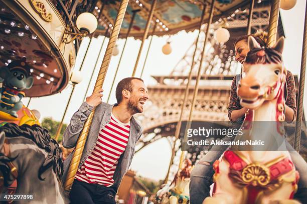 karussellfahrt unter den eiffelturm - couple paris stock-fotos und bilder