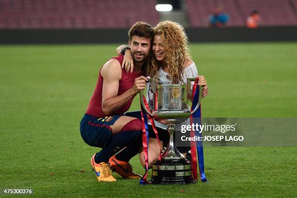 Barcelona's defender Gerard Pique and his wife Colombian singer Shakira pose with the trophy at the end of the Spanish Copa del Rey final football...