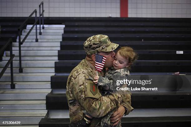 Pfc. Brian Lang of the U.S. Army's 3rd Brigade Combat Team, 1st Infantry Division, kisses his son Johnathan Lang following a homecoming ceremony in...