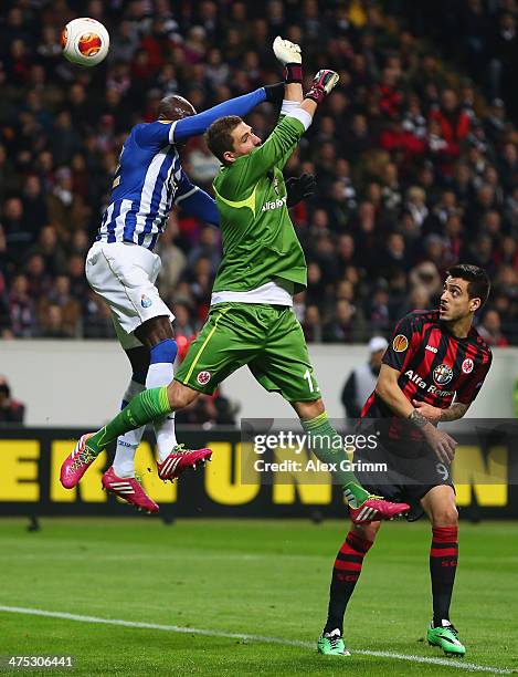 Goalkeeper Kevin Trapp of Frankfurt is challenged by Eliaquim Mangala of Porto during the UEFA Europa League Round of 32 second leg match between...