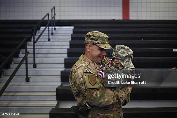 Pfc. Brian Lang of the U.S. Army's 3rd Brigade Combat Team, 1st Infantry Division, holds his son Johnathan Lang following a homecoming ceremony in...