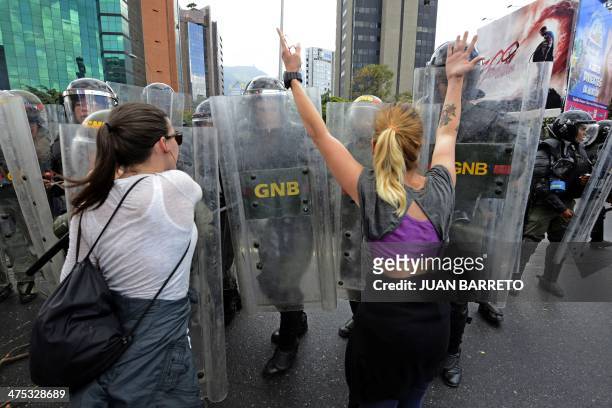 Anti-government demonstrators struggle with members of the National Guard during a protest in eastern Caracas on February 27, 2014. Dueling demos of...