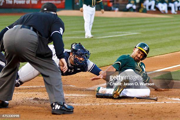 Marcus Semien of the Oakland Athletics is tagged out at home plate by Brian McCann of the New York Yankees in front of umpire Dana DeMuth during the...