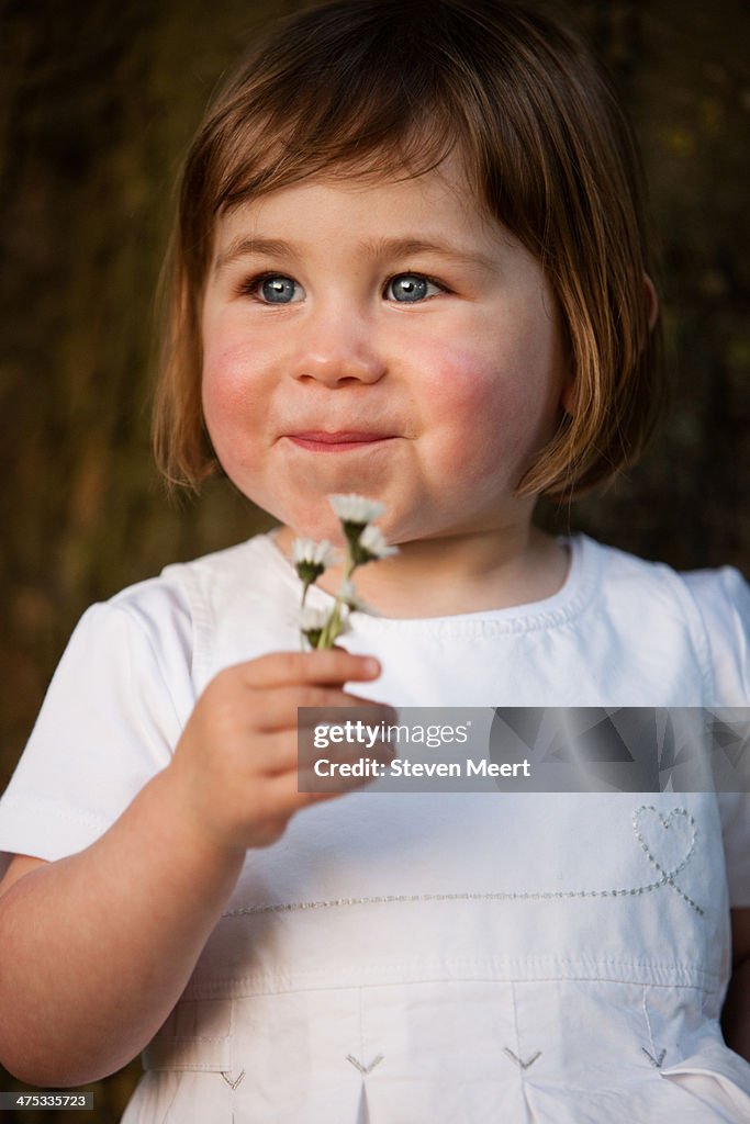 Young girl holding daisy