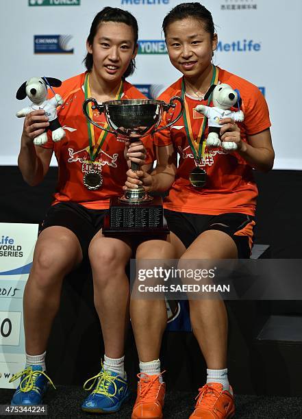 China's Tang Yuanting and Majin pose for pictures with their winning trophy after defeating compatriots Tang Jinhua and Tian Qing in the...