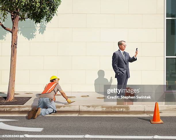 distracted businessman standing in wet cement - ignorance stockfoto's en -beelden