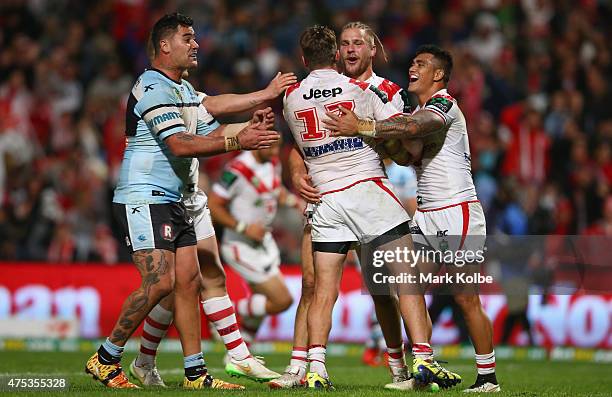 Andrew Fifita of the Sharks appeals to the referee as Will Matthews, Jack de Belin and Peter Mata'utia of the Dragons celebrate de Belin scoring a...