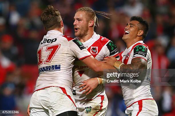 Will Matthews, Jack de Belin and Peter Mata'utia of the Dragons celebrate de Belin scoring a try during the round 12 NRL match between the St George...