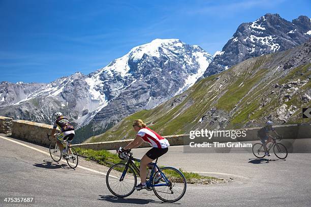 Cyclists ride roadbikes uphill on The Stelvio Pass, Passo dello Stelvio, Stilfser Joch, in the Alps, Italy