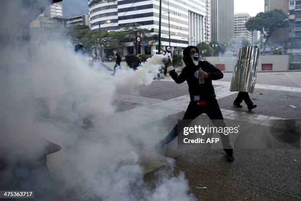 Opponents of Venezuelan President Nicolas Maduro clash with riot police during an anti-government protest in Caracas on February 27, 2014. Dueling...