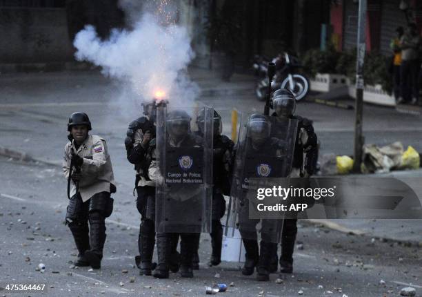 Riot police clash with opponents of Venezuelan President Nicolas Maduro during an anti-government protest in Caracas on February 27, 2014. Dueling...