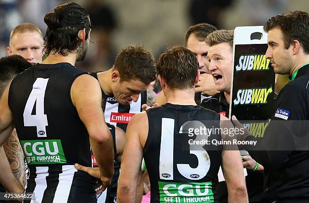 Nathan Buckley the coach of the Magpies talks to his players during the round nine AFL match between the Collingwood Magpies and the North Melbourne...