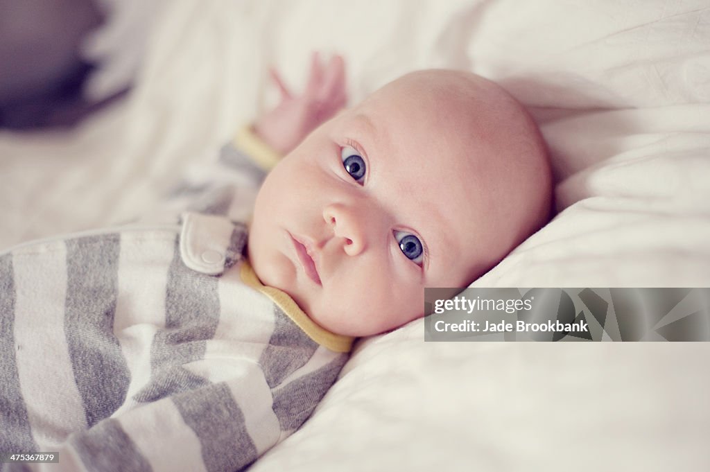 Baby lying on bed