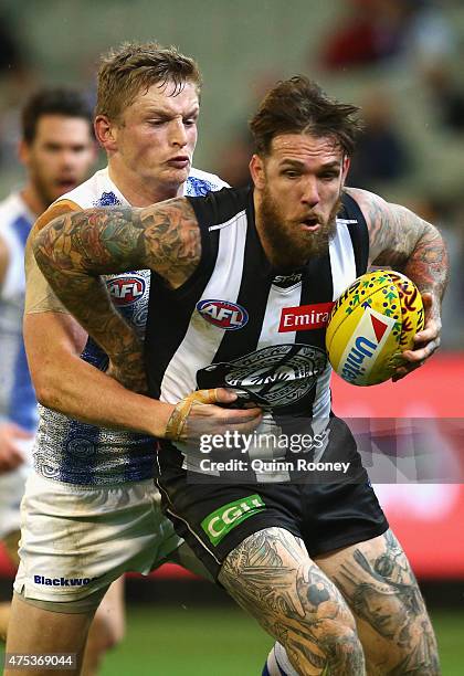 Dane Swan of the Magpies is tackled by Jack Ziebell of the Kangaroos during the round nine AFL match between the Collingwood Magpies and the North...