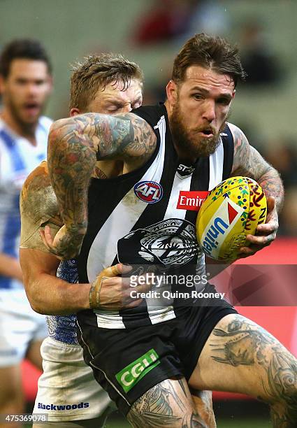 Dane Swan of the Magpies is tackled by Jack Ziebell of the Kangaroos during the round nine AFL match between the Collingwood Magpies and the North...