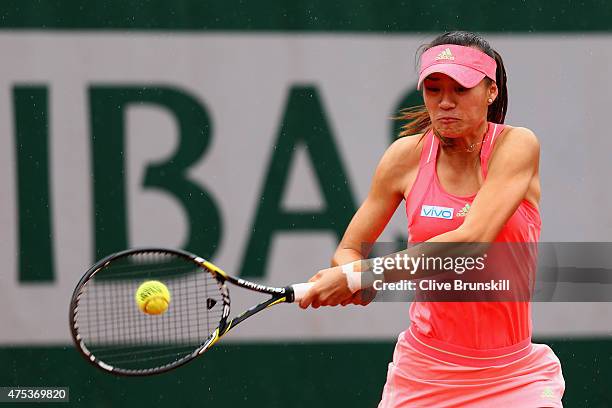 Shilin Xu of China plays a forehand in her girl's singles match against Margot Yerolymos of France on day eight of the 2015 French Open at Roland...