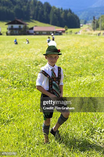 Young boy in costume strolls through flower meadow during traditional beer festival in the village of Klais in Bavaria, Germany