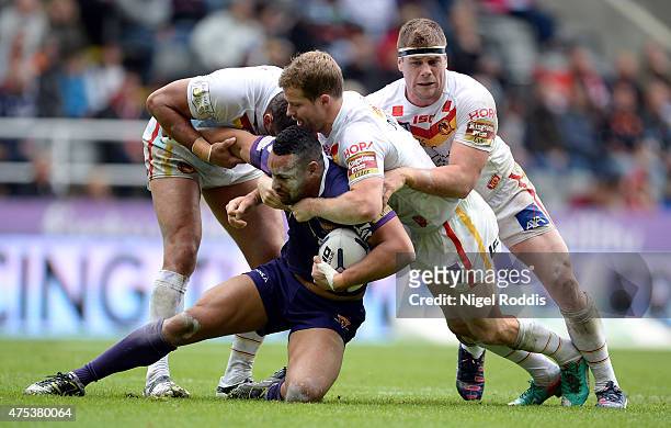 Olivier Elima Remi Casta and Scott Dureau of Catalans Dragons tackle Jodie Broughton of Huddersfield Giants during the Super League match between...