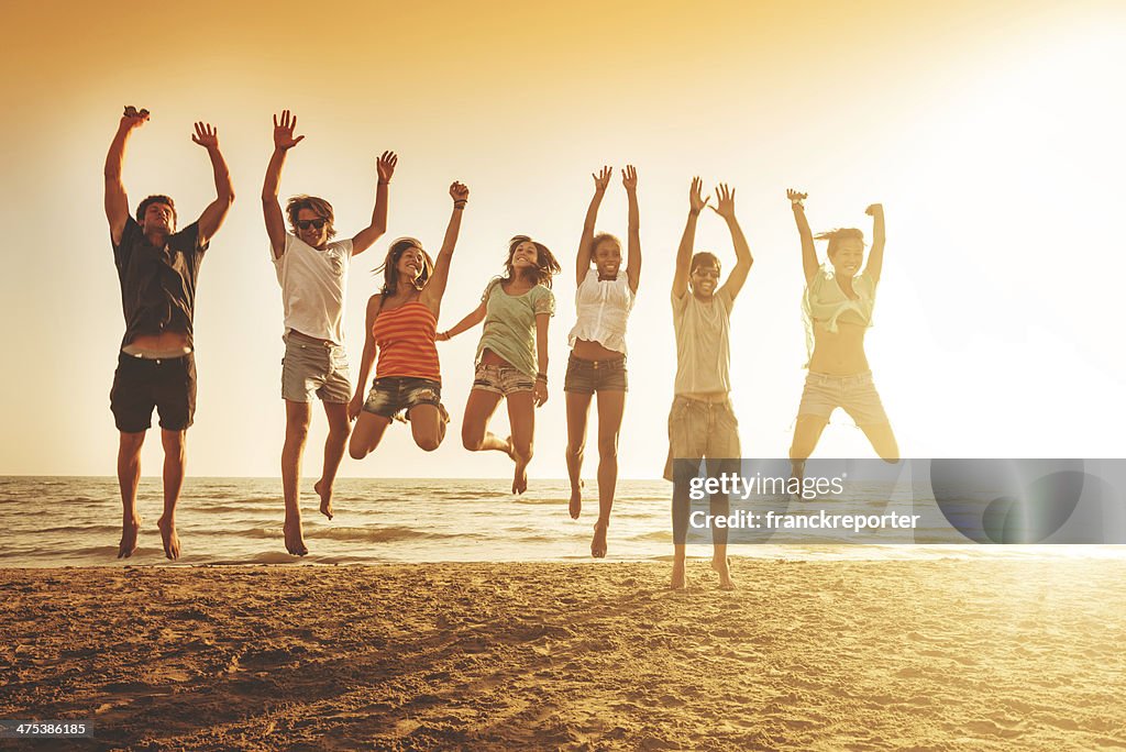 Group of friends jumping on the beach