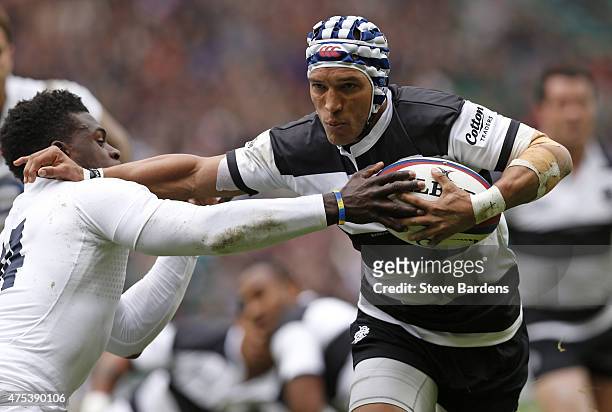 Gio Aplon of the Barbarians is tackled by Christian Wade of England during the match between the Barbarians and England XV at Twickenham Stadium on...