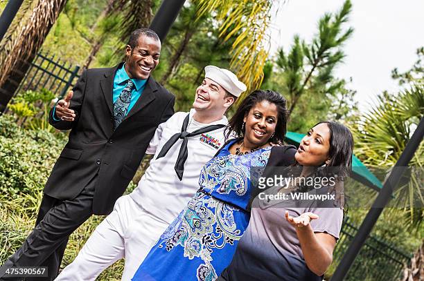 four adult friends walking together arm-in-arm - sailor arm stockfoto's en -beelden