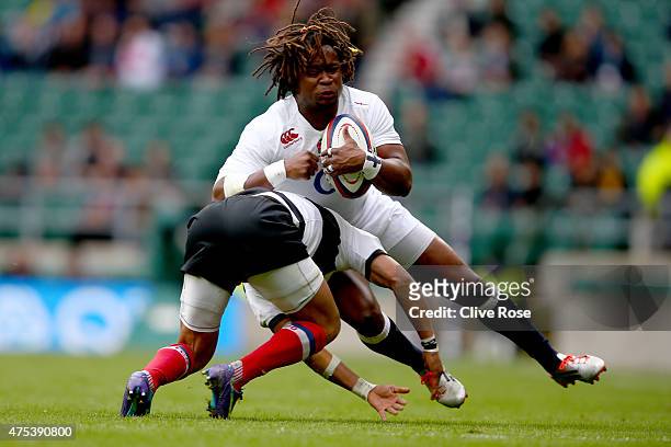 Marland Yarde of England is tackled by Gio Aplon of Barbarians during the England XV v Barbarians match at Twickenham Stadium on May 31, 2015 in...