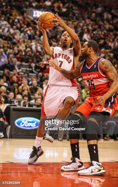 Toronto Raptors point guard Kyle Lowry heads for the hoop past Washington Wizards power forward Trevor Booker during the game between the Toronto...