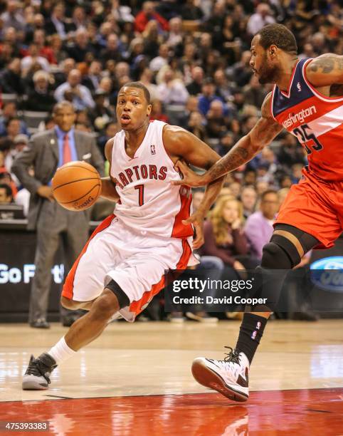 Toronto Raptors point guard Kyle Lowry heads for the hoop past Washington Wizards power forward Trevor Booker during the game between the Toronto...