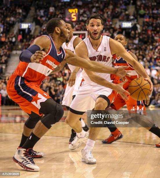 Toronto Raptors point guard Greivis Vasquez looks to pass as he is guarded by Washington Wizards point guard John Wall during the game between the...