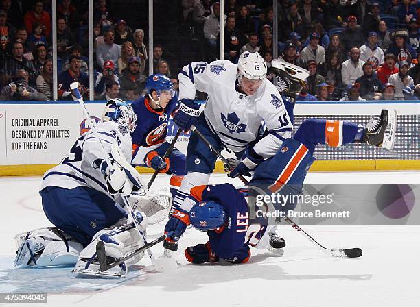 Paul Ranger of the Toronto Maple Leafs trips up Anders Lee of the New York Islanders during the second period at the Nassau Veterans Memorial...