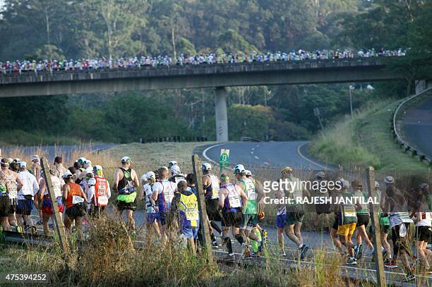 Runners take on May 31,2015 the start of the 89km of the 90th Comrades Marathon between Durban and Pietermaritzburg in Durban. The annual ultra...