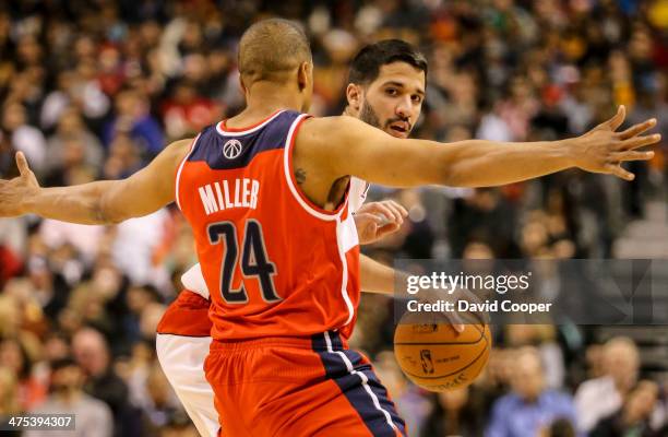 Toronto Raptors point guard Greivis Vasquez looks to pass while being guarded by Washington Wizards point guard Andre Miller during the game between...