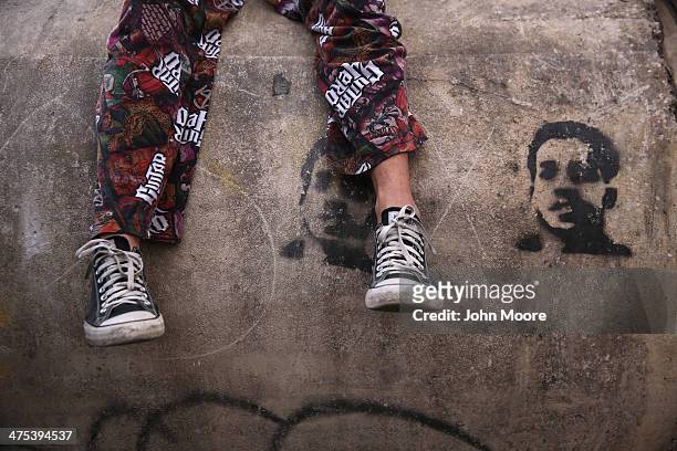 Protester sits over a drawing of a slain student during an anti-government demonstration on February 27, 2014 in Caracas, Venezuela. More than two...