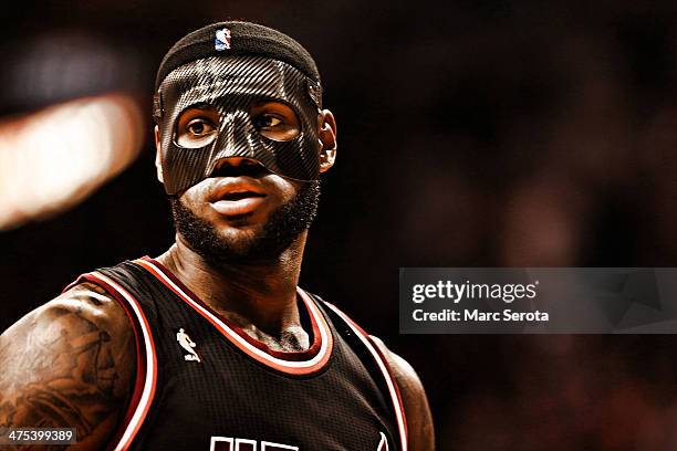 LeBron James of the Miami Heat wears a mask to begin the game against the New York Knicks at AmericanAirlines Arena on February 27, 2014 in Miami,...