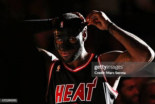 LeBron James of the Miami Heat wears a mask to begin the game against the New York Knicks at AmericanAirlines Arena on February 27, 2014 in Miami,...