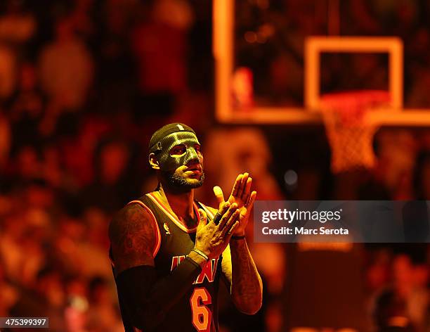 LeBron James of the Miami Heat wears a mask to begin the game against the New York Knicks at AmericanAirlines Arena on February 27, 2014 in Miami,...