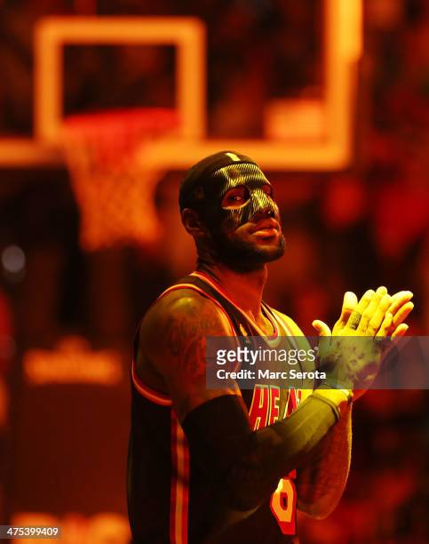 LeBron James of the Miami Heat wears a mask to begin the game against the New York Knicks at AmericanAirlines Arena on February 27, 2014 in Miami,...