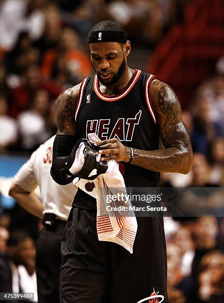 LeBron James of the Miami Heat dries off his protective mask to begin the game against the New York Knicks at AmericanAirlines Arena on February 27,...