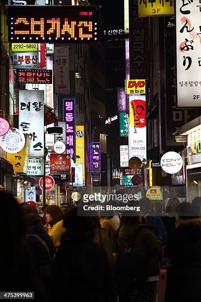Illuminated signboards light up a street in the evening in the Myeongdong district of Seoul, South Korea, on Thursday, Feb. 27, 2014. South Korea is...
