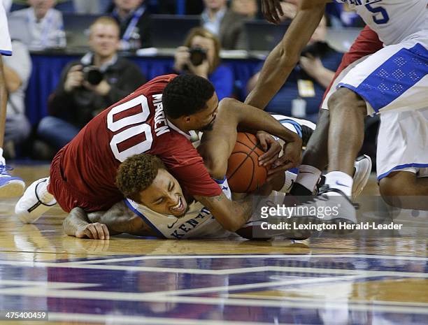Kentucky Wildcats guard/forward James Young wrestles with Arkansas Razorbacks' Rashad Madden for a loose ball at Rupp Arena in Lexington, Ky., on...