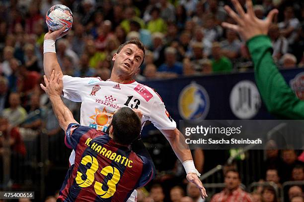 Momir Ilic of Veszprem is challenged by Nikola Karabatic of Barcelona during the "VELUX EHF FINAL4" final match between FC Barcelona and MKB-MVM...