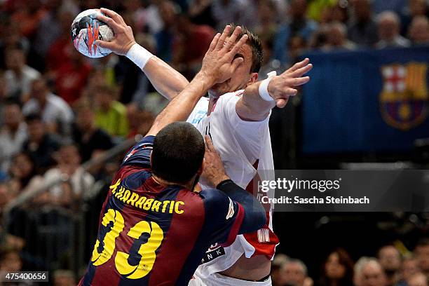 Momir Ilic of Veszprem is challenged by Nikola Karabatic of Barcelona during the "VELUX EHF FINAL4" final match between FC Barcelona and MKB-MVM...