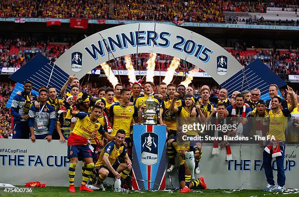 Arsenal players celebrate with the trophy after the FA Cup Final between Aston Villa and Arsenal at Wembley Stadium on May 30, 2015 in London,...