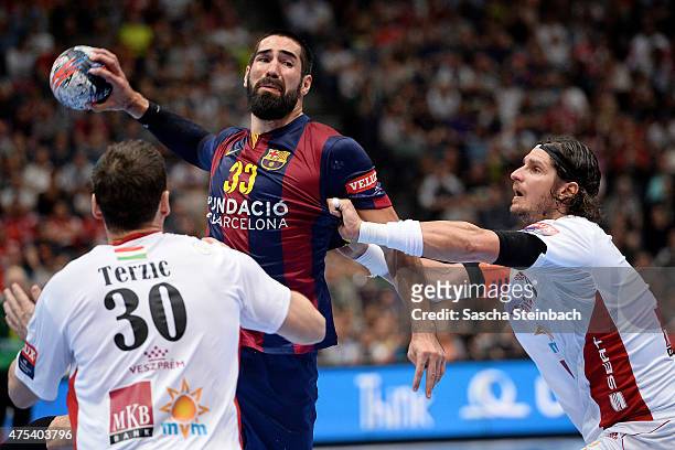 Nikola Karabatic of Barcelona is challenged by Mirsad Terzic and Laszlo Nagy of Veszprem during the "VELUX EHF FINAL4" final match between FC...
