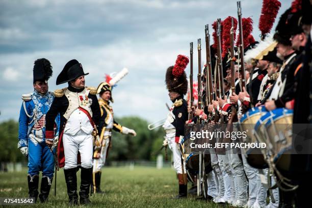 Man dressed as Napoleon Bonaparte next to men dressed as Napoelon soldiers take part in a reenactament event on May 31, 2015 in Chalon sur Saone. AFP...