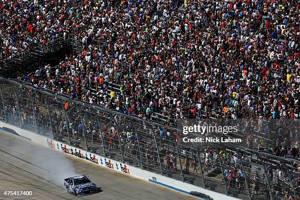 Jimmie Johnson, driver of the Lowe's Pro Services Chevrolet, salutes the crowd after winning the NASCAR Sprint Cup Series FedEx 400 Benefiting Autism...