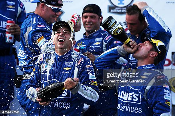 Chad Knaus, crew chief of the Lowe's Pro Services Chevrolet, bottom left, is sprayed with champagne and beer in Victory Lane after winning the NASCAR...
