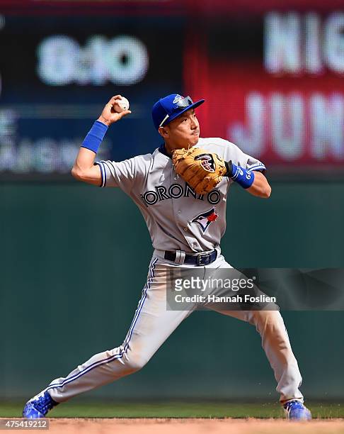 Munenori Kawasaki of the Toronto Blue Jays throws to get out Eduardo Nunez of the Minnesota Twins at first base during the eighth inning of the game...
