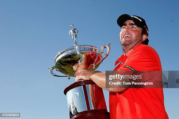 Steven Bowditch of Australia celebrates with the trophy after his four-stroke victory at the AT&T Byron Nelson at the TPC Four Seasons Resort Las...